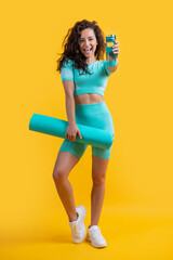 glad athlete in sportswear with fitness mat and sport bottle in studio. fitness athlete