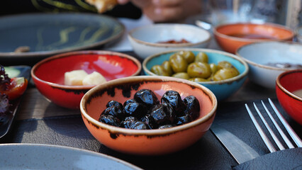 There are colourful bowls of olives and other food on the table. Close-up. A traditional Turkish breakfast. Tomorrow at the cafe.