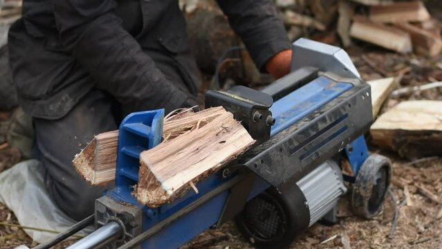 Hydraulic wood splitter splits wormwood. Preparation for the winter.
