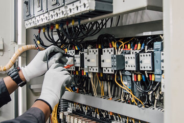 Electrician engineer tests electrical installations and wires on relay protection system. - obrazy, fototapety, plakaty