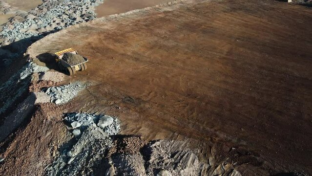 big mining truck in the quarry rides with iron ore overflight drone