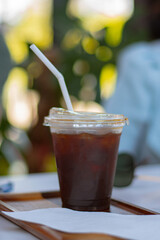 Black coffee, Americano coffee in plastic coffee cup on white table in coffee shop.