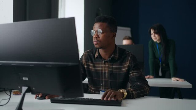 office of international development company, african man working with computer, programmer