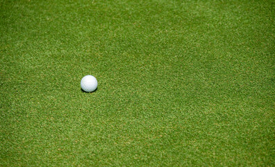 A golf ball on the green in golf course.