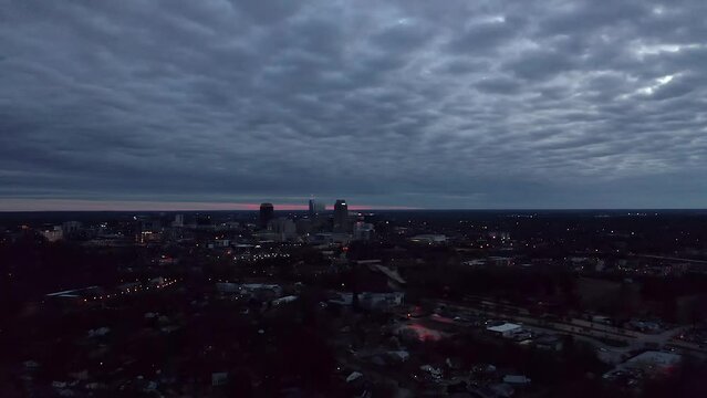 Aerial establishing shot of Raleigh North Carolina at night. Distant American city skyline.