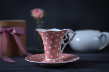 A cup of coffee and a rose on a dark background