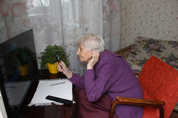 The senior woman watching tv at home.