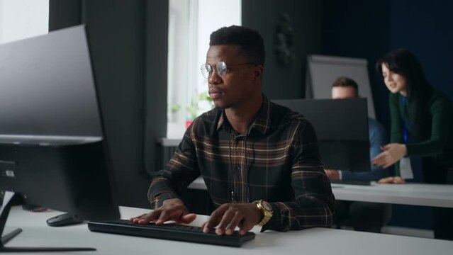 portrait of black man data analyst in office, work with computer, modern IT profession