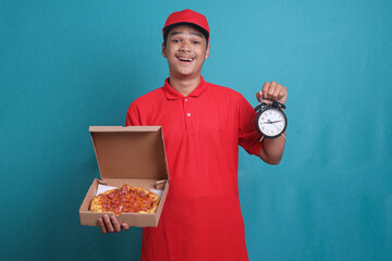 Delivery worker in red uniform is holding boxes of pizza and a clock. On time fast food delivery...