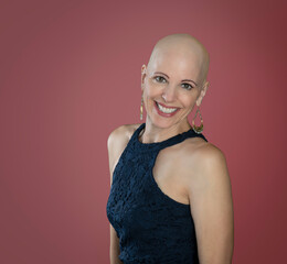Stylish smiling middle aged over 50 woman survivor with alopecia isolated on pink background - 569442815