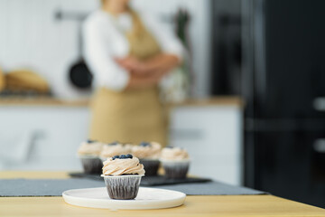 Delicious mini muffins with chocolate flavor for breakfast are on the table in a white bowl. Place for text