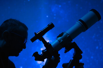 Astronomer looking at the starry skies with a telescope.