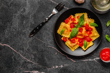 Delicious appetizing ravioli with tomato sauce and basil