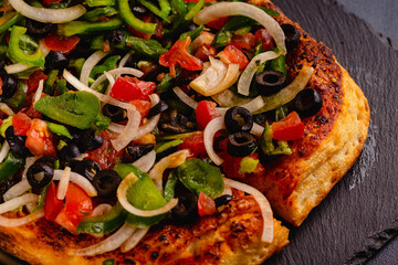 Homemade vegan pizza with tomatoes, peppers, olives, onions.