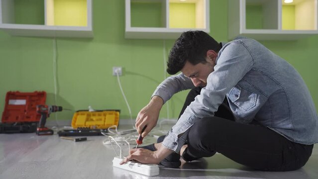 Clumsy and insecure young man gets electrocuted while repairing a socket at home. The incompetent man with no job security was electrocuted while repairing the sockets in his house.
