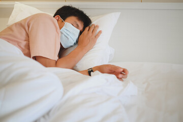 Asian male patient sleeping on bed with face mask in recovery room in hospital ward. 