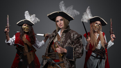 Shot of glamour female pirates dressed in stylish antique clothes looking at camera.