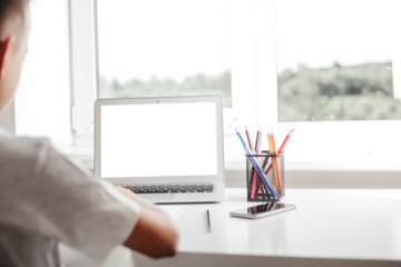 school at home through online homeschooling. the child is sitting at the computer