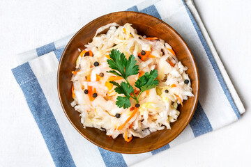 sour cabbage in wooden bowl pepper on white table Fermented vegetable concept Healthy food Top view