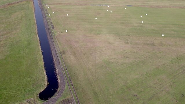 Revealing drone footage of place called Uetz in Brandenburg, Germany. Autumn colors and atmosphere, ascending view of water channel running through fields.