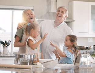 Obraz premium Funny family, baking and children helping grandparents in home kitchen with food. Woman, man and girl kids learning to make cookies, pancakes or cake for breakfast with love, care and fun teamwork