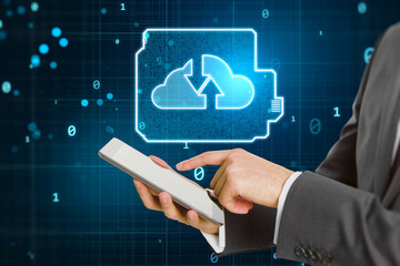 Close up of businessman hand pointing at mobile phone with glowing cloud computing circuit hologram on dark background. Data storage and technology concept.