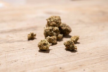 dried cannabis flowers isolated on rustic wooden background as a medicinal remedy