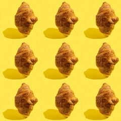 Seamless pattern with chocolate croissant on yellow background.	