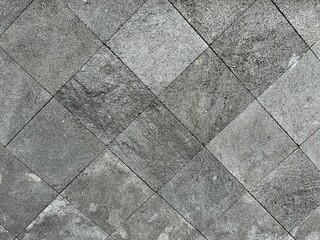 Background of limestone square tile arranged diagonally with rough texture for wall construction.