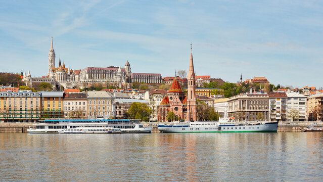 Matthias Church and Reformed church with docked ship on Danube river, Budapest, Hungary