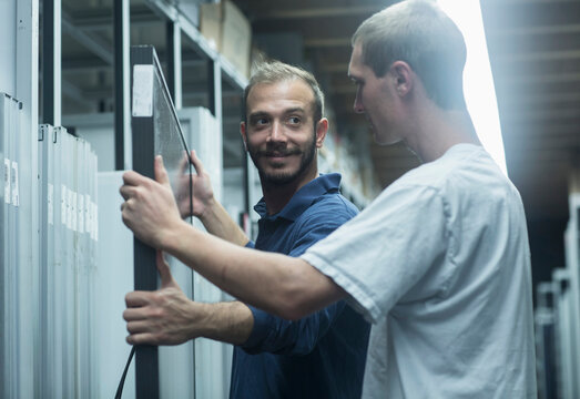 Store workers working in a distribution warehouse, Freiburg im Breisgau, Baden-Württemberg, Germany