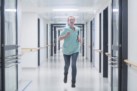 Female nurse running in hospital hallway