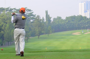 An unidentified amateur Asian golfer practise swing slowly before hit the actual golf ball.