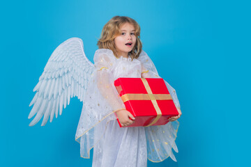 Cute child angel with gift box present. Beautiful little angel. Isolated studio shot. Cute Pretty...