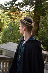 Close up portrait of handsome brunette man wearing fantasy medieval prince costume with golden...