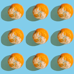 Fototapeta na wymiar Seamless pattern with rotten tangerine on blue background.