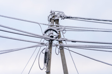 Wires on a pole in the snow. Winter background, selective focus