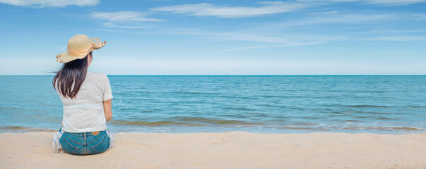 Summer vacation concept at the beach. Young woman in hat relaxing sitting on the sand by the beach Enjoy looking at the view of the ocean beach on a hot summer day. copy space