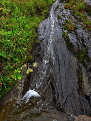 Austrian Alps - view of a small waterfall on a stream by the footpath from the Karl von Edel hut to the upper station of the Ahornbahn cable car