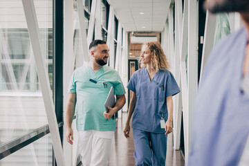 Multiracial male and female hospital staff walking in corridor