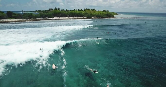 Drone shot of tourists enjoying surfing in sea