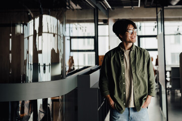 Fototapeta na wymiar Positive asian business man walking through modern office space