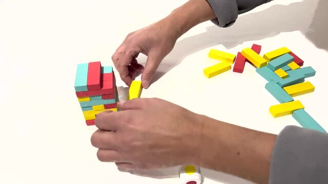 Time lapse delle mani di una donna che compongono la torre dei gioco dei mattoncini colorati