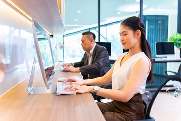 Asian businesswoman in formal suit working in modern luxury office using computer for business and education