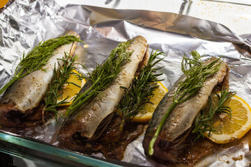 mackeremackerel fish with rosemary and lemon dish, several objects, served lying on the sheet for baking in the oven in the kitchen.concept recipe fish with rosemary fish with rosemary and lemon dish