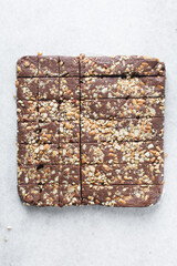 Top view of chocolate fudge with nuts on a marble board, chocolate fudge cut into pieces, fudge candy on a chopping board