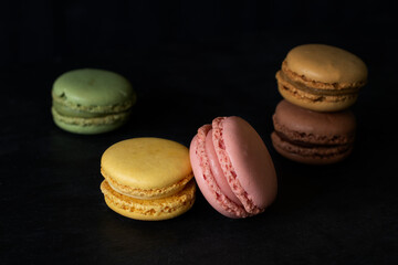 Macarons composition in balance on black background