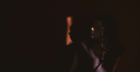 young woman on black background with light and shadow on face