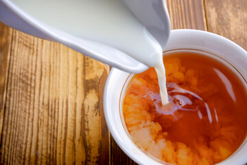 cup of tea with milk on a wooden table