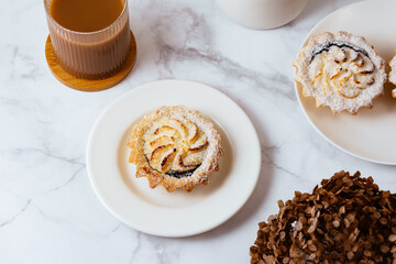 dessert on a plate and coffee with milk in a glass.